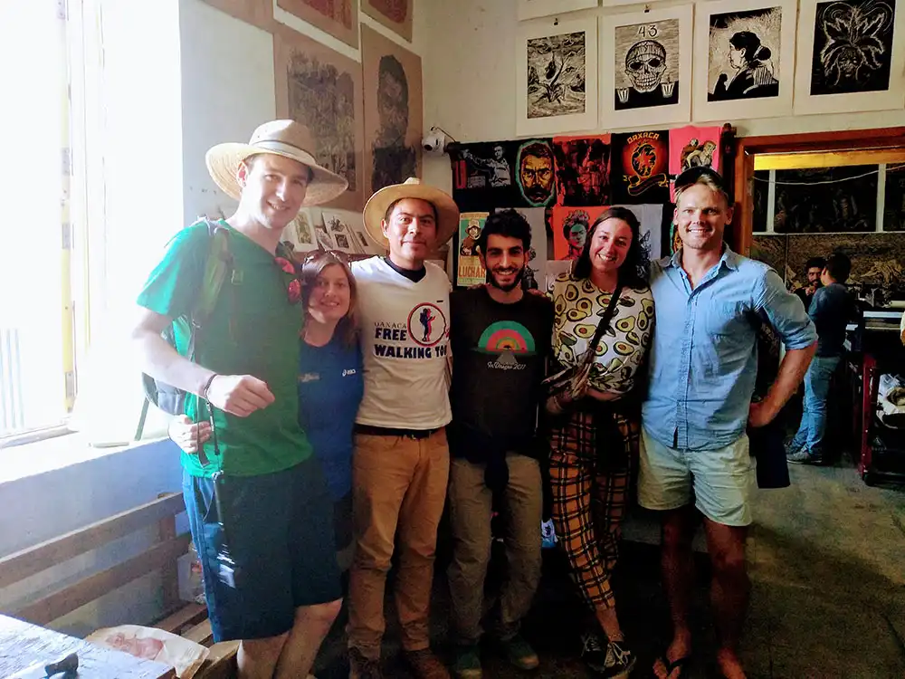 Small private tour group with local guide exploring historic Oaxaca building interior